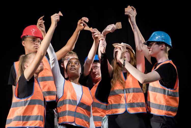 group of students wearing orange high vis jackets and construction hats