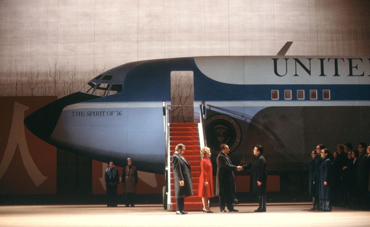 Two men shake hands in front of a United Airlines plane